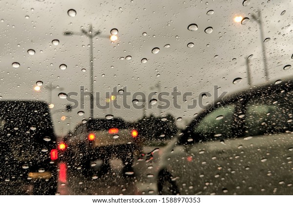 window\
of the car during rainy day with water eye\
drops