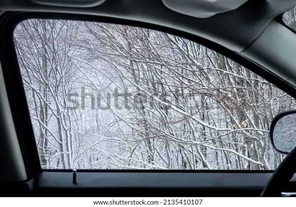 window car view of snow and winter trees in\
Pelion mountain in\
Greece.