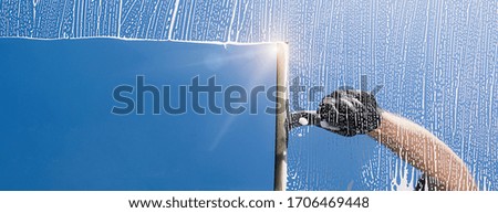 Window cleaner cleans window with foam and puller, banner size, banner size, panorama, with copyspace for your individual text.