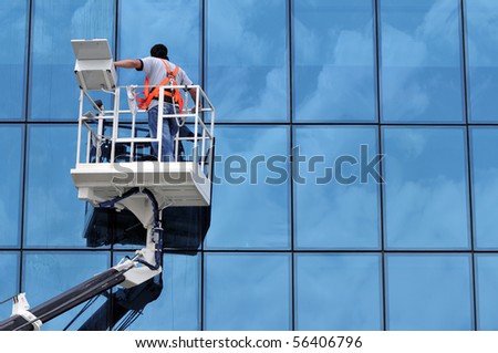 Window cleaner working on a glass facade in a gondola