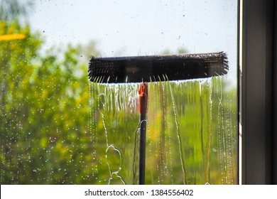 Window Cleaning Using Telescopic Water Brush And Wash System. Commercial Window Cleaning From The Outside With Sky And Trees In Background 