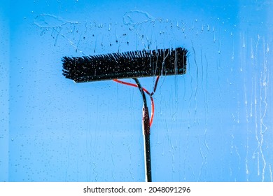 Window Cleaning Using Telescopic Water Brush And Wash System. Commercial Window Cleaning From The Outside With Sky In Background. Defocused