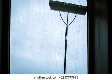 Window Cleaning Using Telescopic Water Brush And Wash System. Commercial Window Cleaning From The Outside With Sky In Background. Defocused