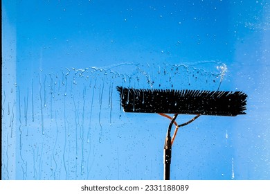 Window cleaning using telescopic water brush and wash system. Commercial window cleaning from the outside with sky in background. Defocused - Powered by Shutterstock