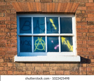 window covered in graffiti and anarchy signs