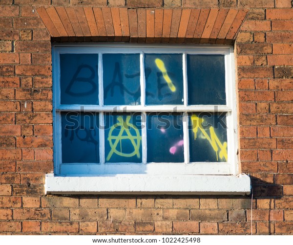 window covered in\
graffiti and anarchy\
signs