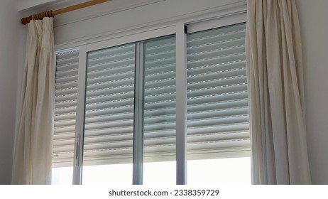 window with curtains and blind going down