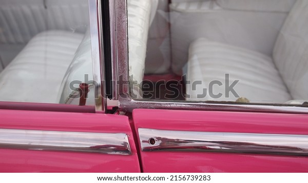 Window\
frames of a pink retro car close-up, Cuba,\
Havana