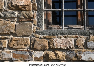 window with grating and stone wall
