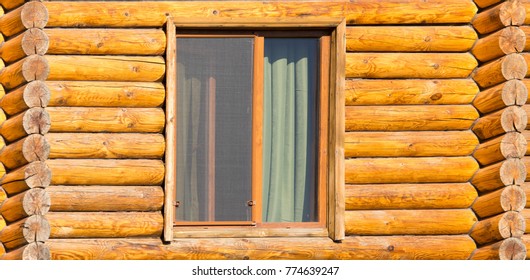Window in the house with a log house
