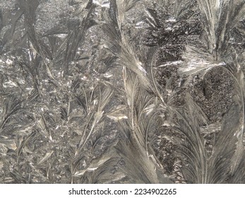 Window ice makes fantastic silvery patterns on the glass. - Shutterstock ID 2234902265