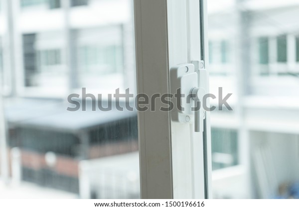 Window lock handle of modern home looking outside\
the house.