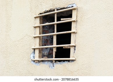 Une fenêtre avec un treillis métallique dans le bâtiment de la prison.