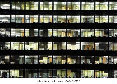 Window Of The Multi-storey Building Of Glass And Steel Office Lighting And Working People Within