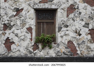 
The window of an old historic building whose walls appear to have been peeled off and damaged.