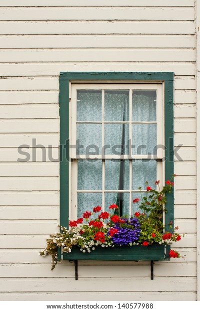 A\
window of an old house with a flower planter\
box.