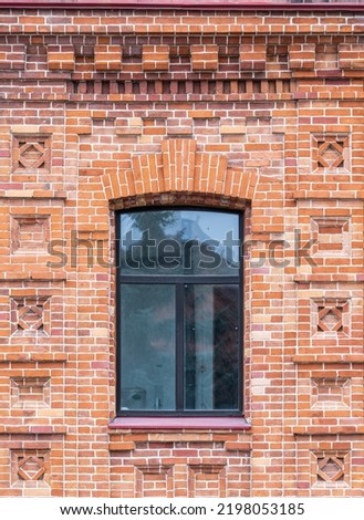 The window of the old mansion 19 century with brown bricks wall. Brick wall of an old 19th century building with large window.