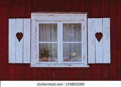 Window With Old Wooden White Shutters With Hearts Cut Out In A Red Swedish House In Falu Red