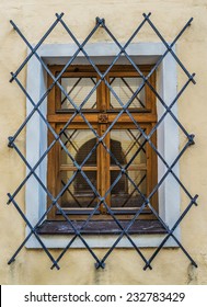 Window on an old European building with wrought iron bars.
