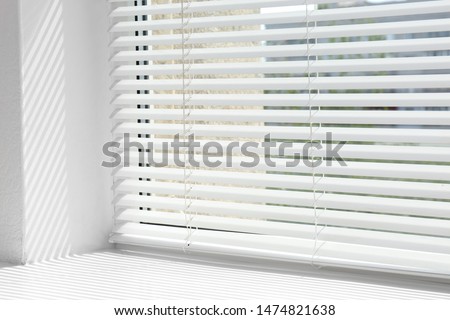 Window with open modern horizontal blinds indoors, closeup