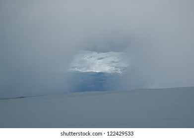 Window opened in thick cloud on a mountain slope. Ice-fall could be seen through the window.