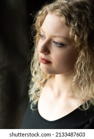 Window Portrait Of A 21 Year Old White Blonde Woman With Curling Hair