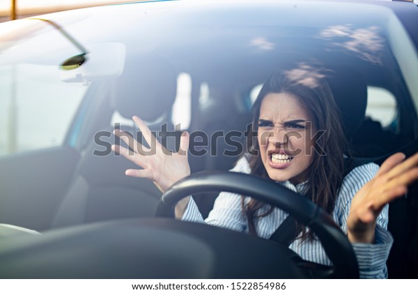 Window portrait displeased stressed angry\
pissed off woman driving car annoyed by heavy traffic isolated\
street background. Emotional intelligence concept. Negative human\
face expression