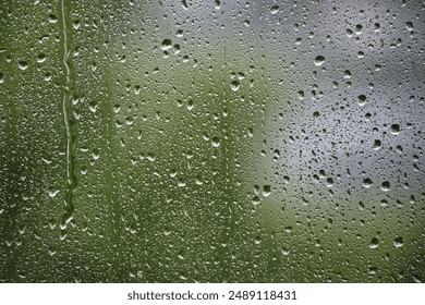 Window with raindrops on it. The raindrops are small and scattered, creating a blurry effect. Scene is calm and peaceful, as the raindrops fall gently on the window - Powered by Shutterstock