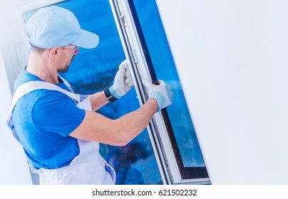 Window Replacement Installation By Professional Caucasian Construction Worker. Home Building Or Remodeling Photo Concept.