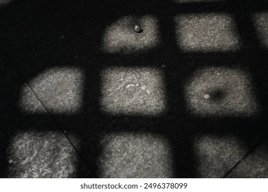 The window shadow leaves nine-grid on the ground, with a pearl earring in the grid