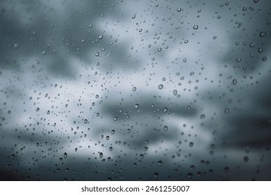 Window with small raindrops on the surface of a glass against a blue cloudy sky after a storm. Weather forecast. Rainy season. Fall or spring cold day. View of the sky from the window. Air concept.  - Powered by Shutterstock - Get 15% off with code: PIKWIZARD15