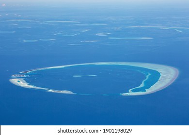 Window view from airplane on maldivian atoll with islands. Aerial shot. Travel destinations