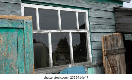 The window of a village house. An old wooden window in a house in the village next to the barn - Shutterstock ID 2355414649