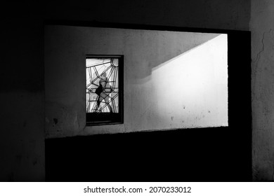 Window in the wall with a reflection of a man