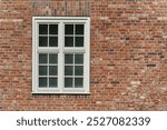 Window with white frame on a historic brick building in Germany