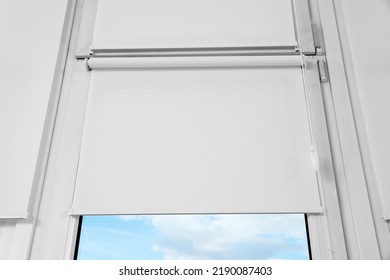 Window with white roller blinds, closeup view