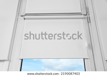Window with white roller blinds, closeup view