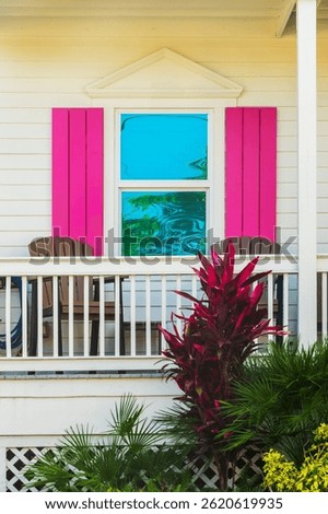 Window of a wooden house with pink shutters, colorful architecture in Bahama village, Key West, Florida