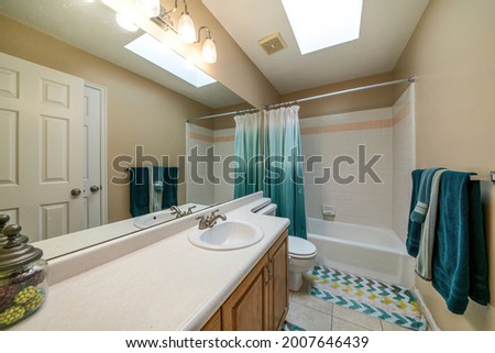 Windowless bathroom interior with long vanity sink