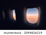 Windows of airplane during flight above clouods at beautiful sunrise. 
