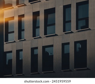 windows of the building in the shade and rays of the setting sun 