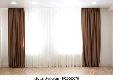 Windows with elegant curtains in modern room