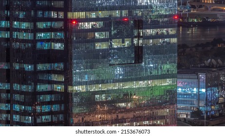 Windows In High-rise Office Building Exterior In The Late Evening With Glowing And Blinking Interior Lights On Timelapse. Aerial Top View