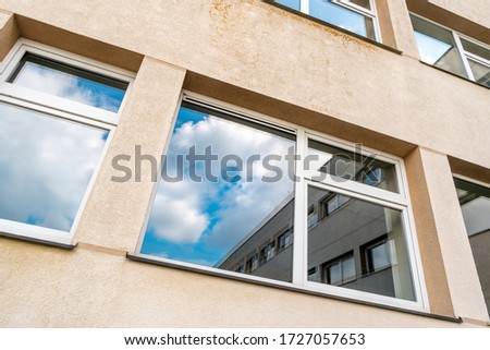 Windows of multistorey building with a blue sky in the reflection
