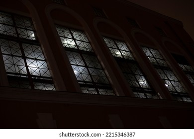 Windows At Night. Light In Windows In Evening. Building Outside In Dark. Lattices On Window Openings.