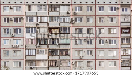 The windows of an ordinary soviet building. Old apartment building with balconies and air conditioning. 