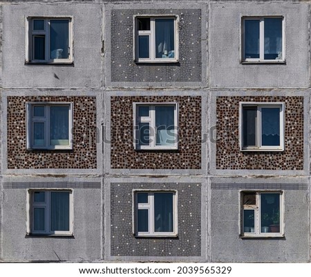 Windows of the residential building. Old urban obsolete facade of panel house. The windows of an ordinary soviet building.