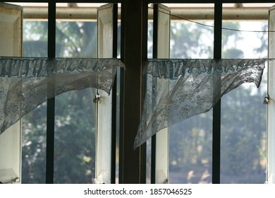 The windows of the room had white curtains that split in the wind. - Shutterstock ID 1857046525
