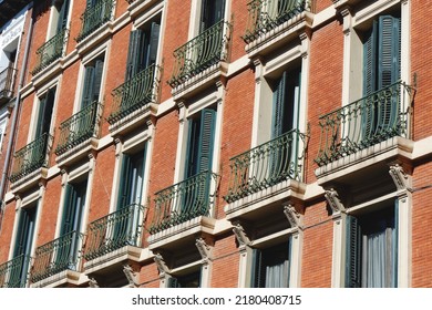 Windows With Shutters And Small Balconies Outside On The Building Facade Downtown Madrid, Spain.