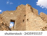 Windows in a wall at the Chaco Canyon Pueblo, New Mexico with clouds in a blue sky.